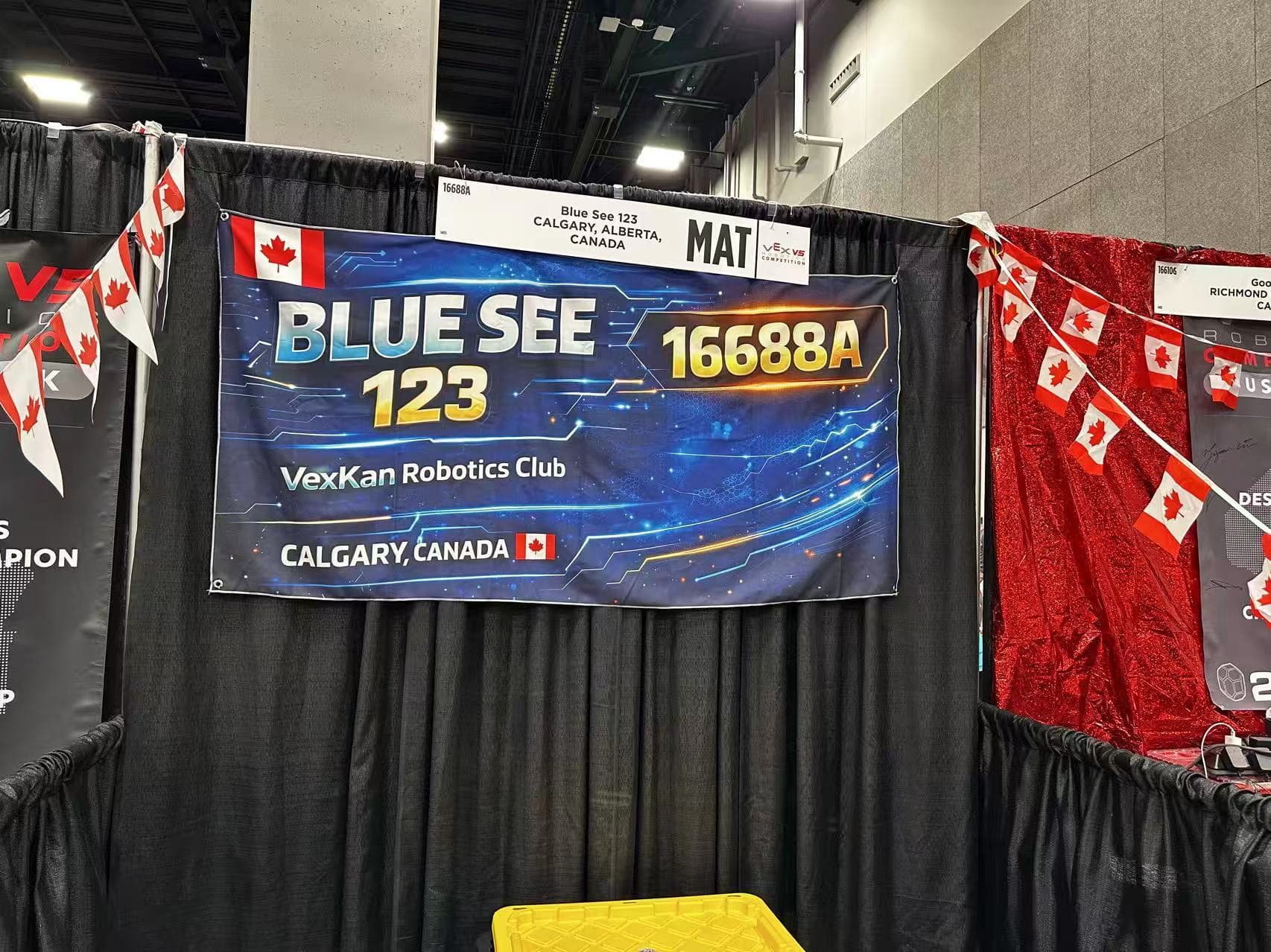 The team's Blue See 123 banner hanging at the back of their pit, with Canadian flags strung across it.