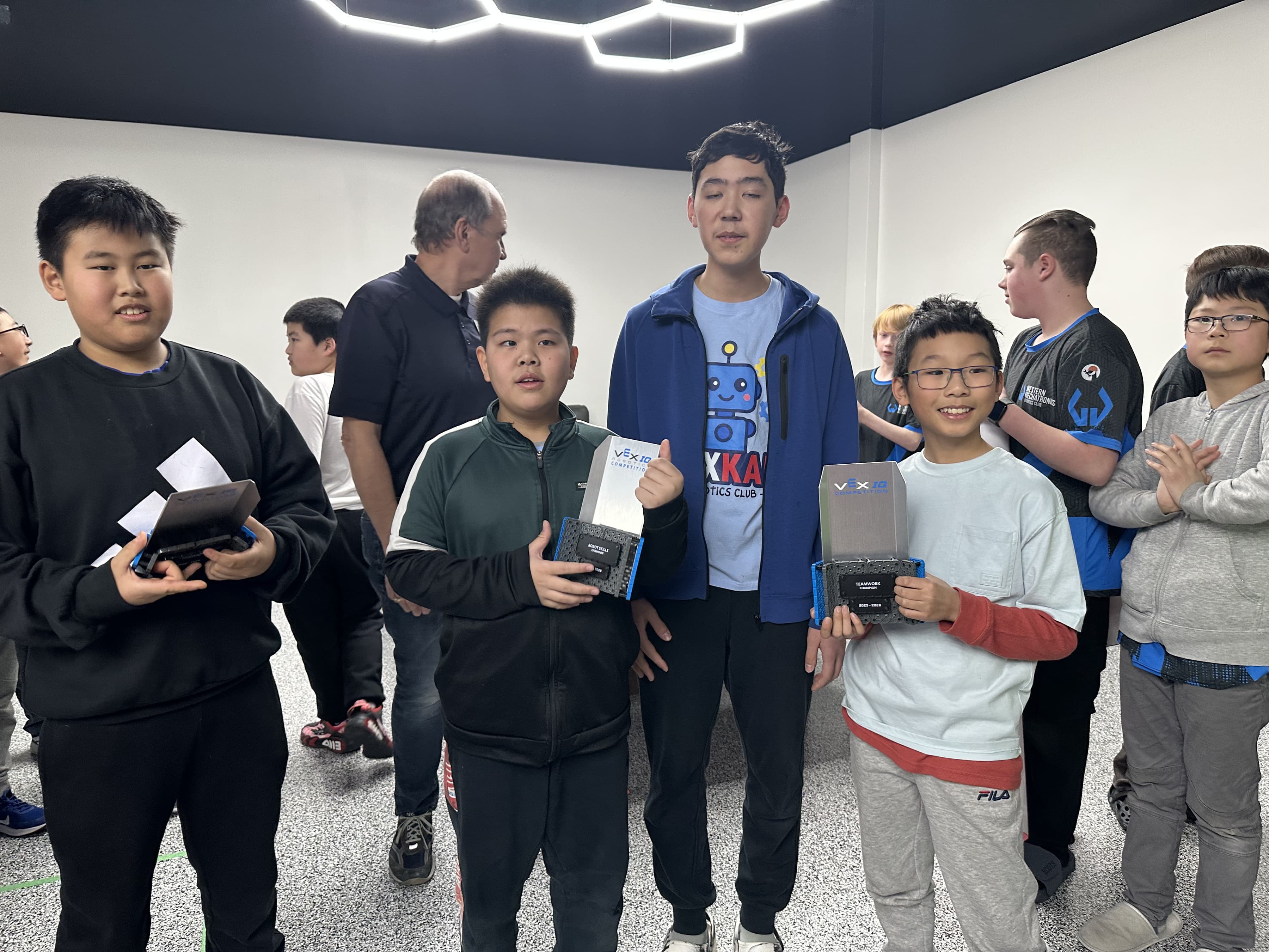 Clubbers standing together in a classroom holding their robot brains and controllers.