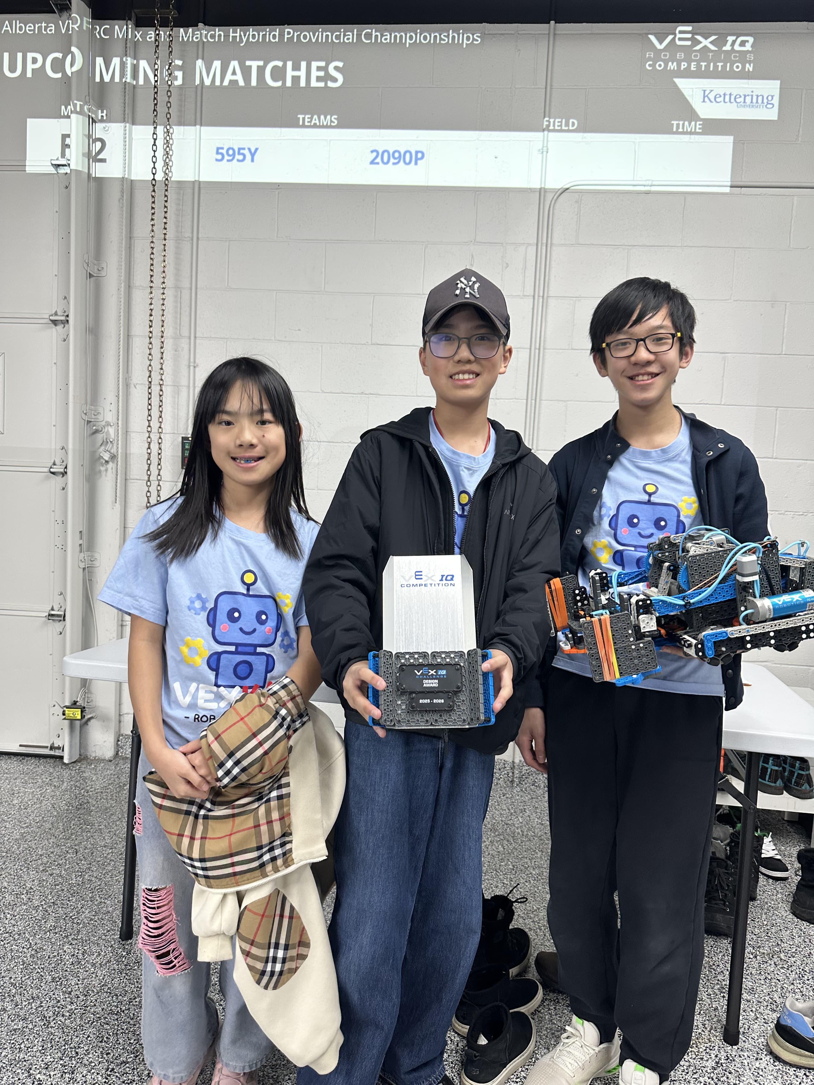 Three members of 595C with their VEX IQ robot and the Design Award trophy at the Alberta provincial championships.