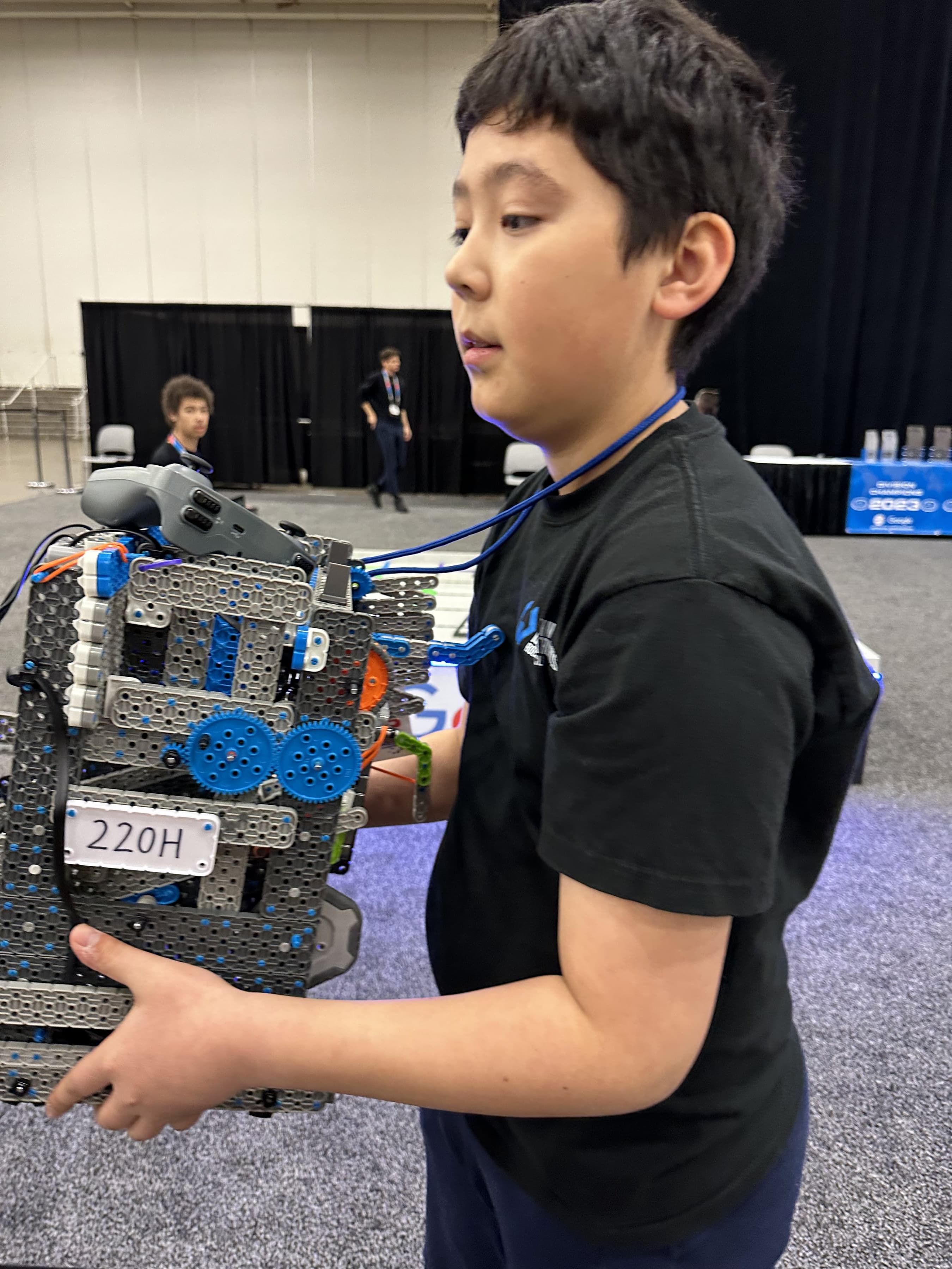 A V5 robot on the pit table, its drivetrain and intake visible from the side.
