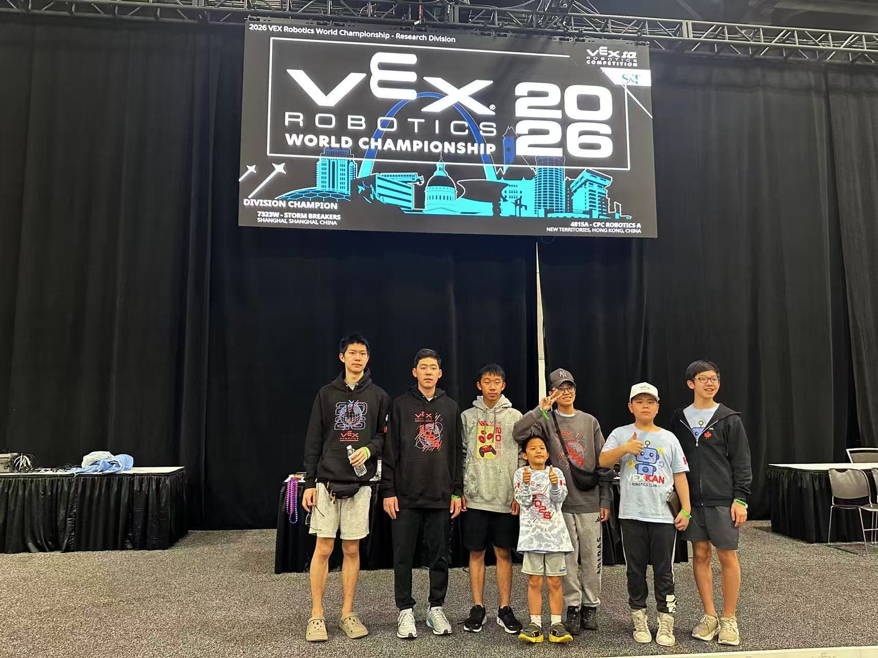 Seven clubbers standing together under the 2026 VEX Robotics World Championship screen in the Research Division.